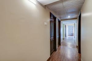 um corredor com paredes brancas e pisos de madeira em OYO Flagship M H Grand em Nalmatha