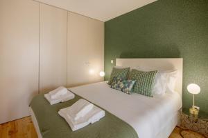 um quarto com uma grande cama branca e paredes verdes em NEW - Bright Studio in Santa Catarina no Porto