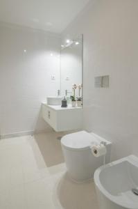 uma casa de banho branca com um WC e um lavatório em NEW - Bright Studio in Santa Catarina no Porto