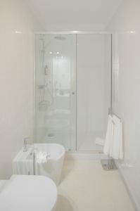 uma casa de banho branca com um chuveiro e um lavatório. em NEW - Bright Studio in Santa Catarina no Porto