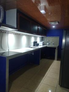 a kitchen with white counter tops and blue cabinets at Cabinas Pacifico in Puntarenas