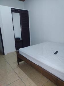 a bed in a room with a remote control on it at Cabinas Pacifico in Puntarenas