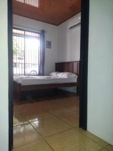 a bedroom with a bed and a window in a room at Cabinas Pacifico in Puntarenas