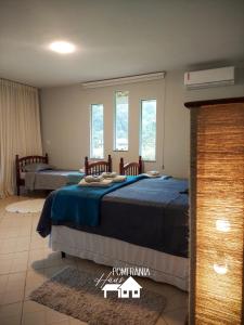 波梅羅迪的住宿－Pomerânia Haus，一间卧室设有两张床和两个窗户。