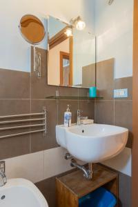 bagno con lavandino, specchio e servizi igienici di Ponte per la Sardegna e la Corsica dalla Toscana family apartment a Livorno