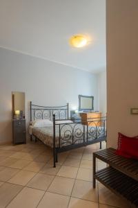 1 dormitorio con cama, TV y banco en Ponte per la Sardegna e la Corsica dalla Toscana family apartment, en Livorno
