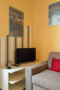 un soggiorno con divano e TV a schermo piatto di Ponte per la Sardegna e la Corsica dalla Toscana family apartment a Livorno