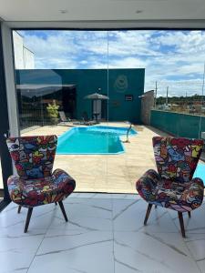 a pair of chairs sitting on a patio with a pool at Pousada José Marineli in São Francisco do Sul