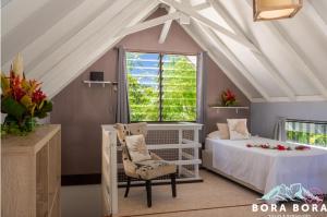 een slaapkamer met een bed en een stoel op zolder bij Matira Sunset House N659 DTO-MT in Bora Bora