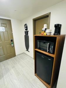 a room with a microwave on a counter and a door at Wingate by Wyndham Williamsburg in Williamsburg