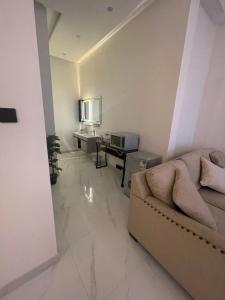a living room with a couch and a table at Al Jadeed Istudio In Al Jubaylah in Al ‘Uyaynah +4 photos