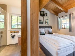 a bedroom with a large bed and a bathroom at Tauernlodge Berglust in Bramberg am Wildkogel