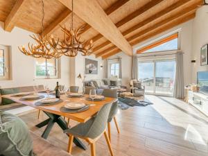 a dining room with a large wooden table and chairs at Tauernlodge Berglust in Bramberg am Wildkogel