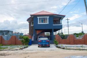a blue car parked in front of a house at Three Bedrooms Beautiful and Spacious contemporary home in Georgetown