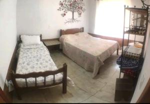 1 dormitorio con 2 camas y mesa en Pouso Casazul en Tiradentes