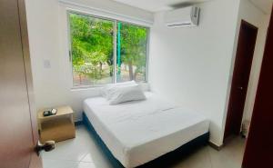 Puerto Gaitán的住宿－Hotel Payara，白色的卧室设有床和窗户