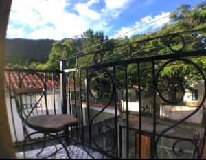 Un balcón con una mesa y una silla. en Pouso Casazul en Tiradentes