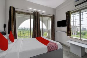 a bedroom with a bed and a large window at Super OYO Flagship J M T Upasana in Kolkata