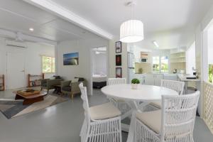 a dining room and living room with a white table and chairs at Coastal Chill in Port Douglas