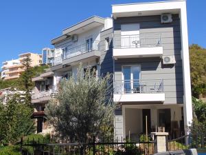 un edificio de apartamentos con balcones y un árbol en Apartments Milic-Ulcinj, en Ulcinj