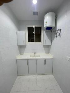 a white bathroom with a sink and a window at شقق خاصة مع حوش مدخل خاص in Sidīs