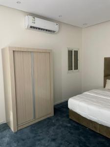 1 Schlafzimmer mit einem Bett und einem Schrank mit Klimaanlage in der Unterkunft شقق خاصة مع حوش مدخل خاص in Sidīs
