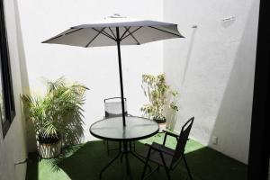 a table and two chairs and an umbrella on a patio at Aura Hotel boutique in Guadalajara