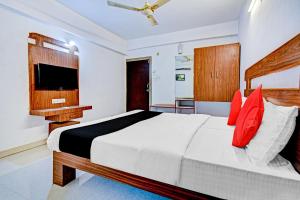 ein Schlafzimmer mit einem großen Bett mit roten Kissen in der Unterkunft Collection O Iris in Chikalthān