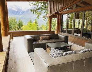 a screened in porch with couches and a table at New Denver Lodge in New Denver