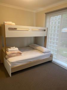 Etagenbett in einem Zimmer mit Fenster in der Unterkunft Lifestyle Apartments at Ferntree in Fern Tree Gully
