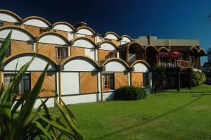 a building with arches on the side of it at Hosteria Querandi in Villa Gesell