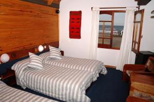 two beds in a room with a view of the ocean at Hosteria Querandi in Villa Gesell +2 photos