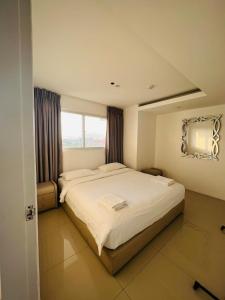 a bedroom with a large bed and a window at Chequers Suites Subic Bay in Olongapo
