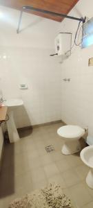 a bathroom with two sinks and a toilet in a room at Finca Huallpamarjka in Salta