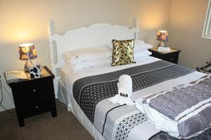 a bedroom with a large bed and two night stands at The Beach House Bed and Breakfast in Maungatapu