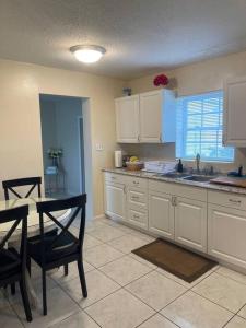 a kitchen with white cabinets and a table and chairs at 2 Bedroom House, Ideal for a Family in Fort Pierce