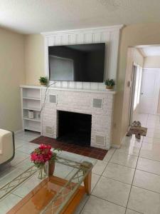 a living room with a fireplace with a flat screen tv at 2 Bedroom House, Ideal for a Family in Fort Pierce