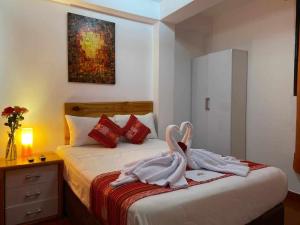 een slaapkamer met een bed met handdoeken erop bij Fenix Hotel Machupicchu in Machu Picchu