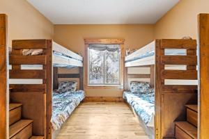 two bunk beds in a room with a window at New! Black Bear Inn - Pet friendly - trailer parking - walk to lake - rustic in Donnelly