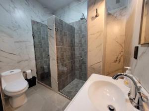 y baño con ducha, aseo y lavamanos. en Great location Apartment in Pachuca en Coscotitlán