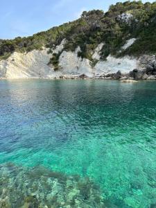 a large body of water next to a rocky shore at Casita Bonita - with private garden near beach in Jávea in Jávea