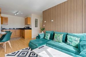 uma sala de estar com um sofá verde e uma cozinha em City View Free Parking Sleep 6 em Leicester