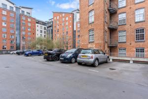 a row of cars parked in a parking lot next to a building at City View Free Parking Sleep 6 in Leicester