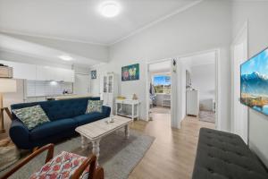 ein Wohnzimmer mit einem blauen Sofa und einem Tisch in der Unterkunft Clementine in Katoomba