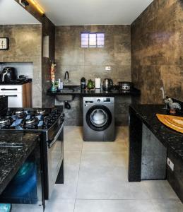 a kitchen with a washing machine and a stove at Casa da Nivea in São Paulo