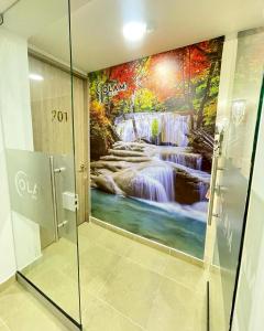 a bathroom with a painting of a waterfall at Hotel Olam Deluxe Valledupar in Valledupar