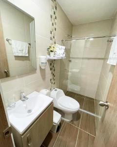 uma casa de banho com um WC, um lavatório e um chuveiro em Hotel Olam Deluxe Valledupar em Valledupar