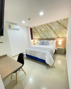 a large bedroom with a large bed and a table at Hotel Olam Deluxe Valledupar in Valledupar