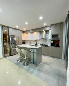 a kitchen with a large white island in a room at Hotel Olam Deluxe Valledupar in Valledupar