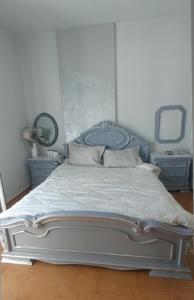 1 dormitorio con 1 cama con espejo y TV en Maison de Couture, en Kalymnos